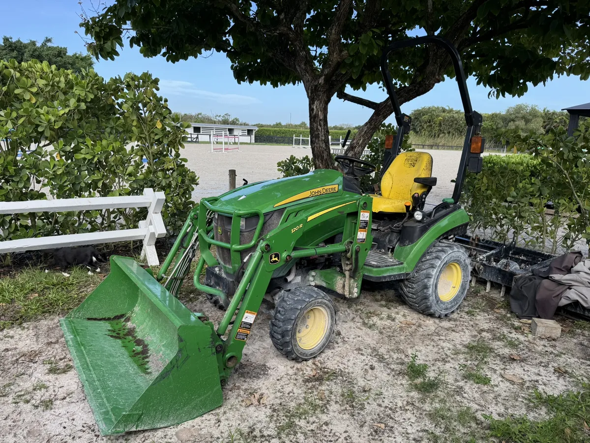 John Deere tractor with front loader beside the pond on a Florida horse farm